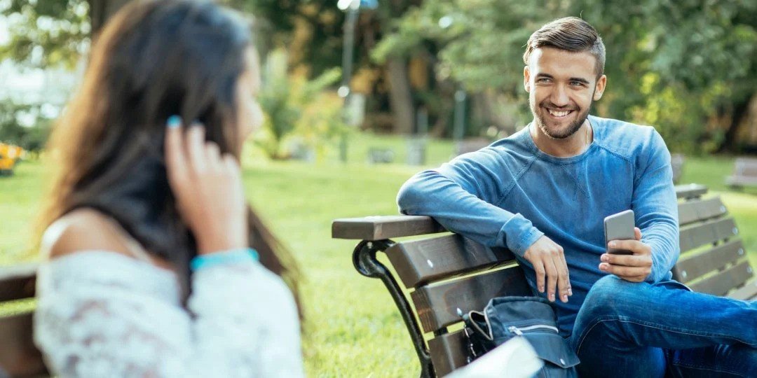 men and women speaking in park