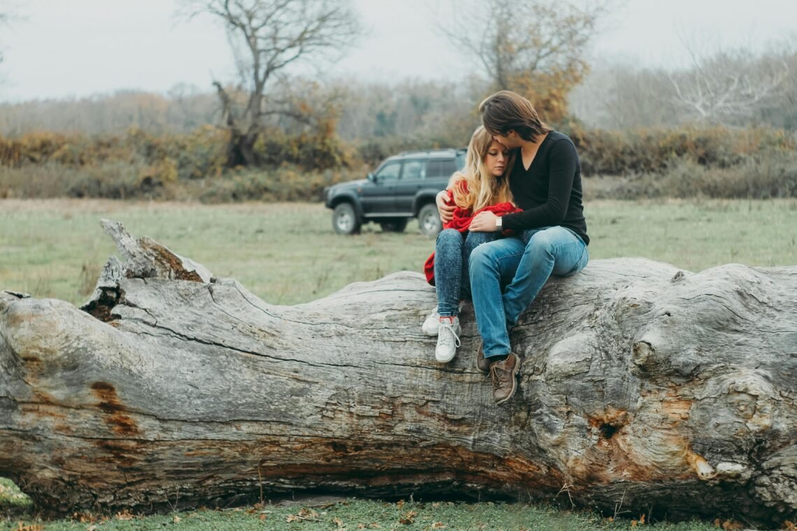 Boyfriend and Girlfriend Sitting on Tree Log