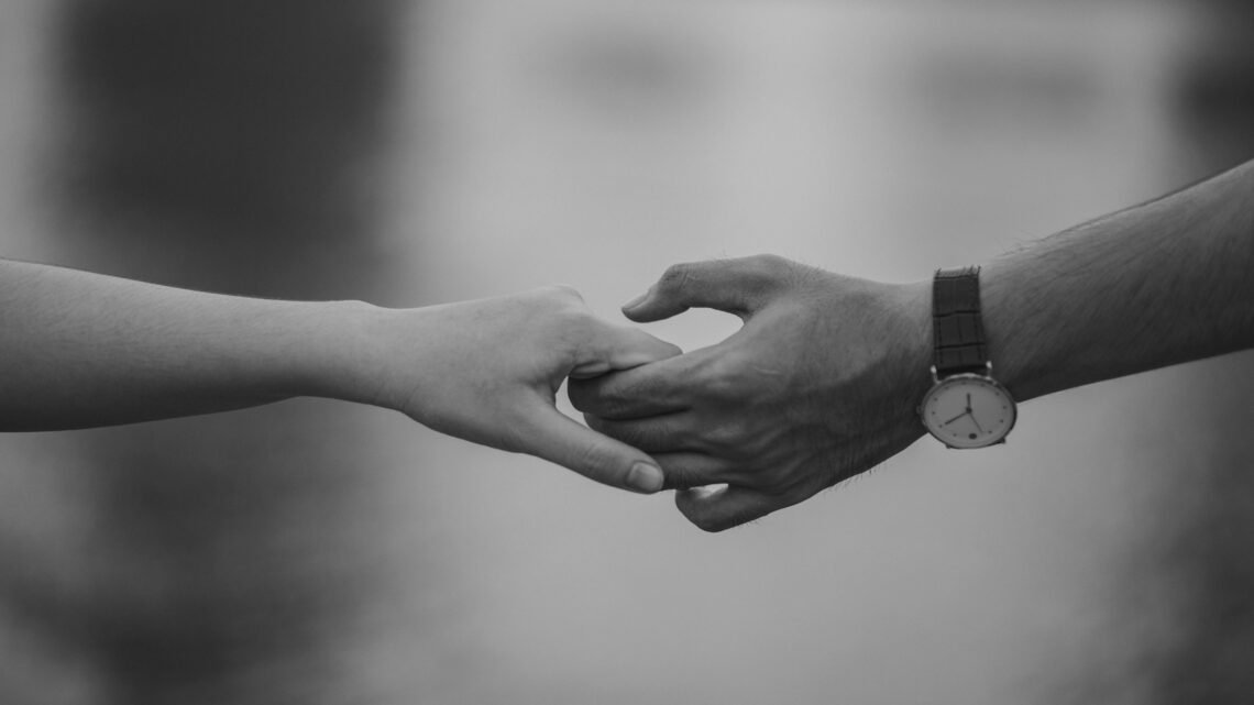 two hands hanging each other