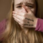 Woman in Purple Shirt Covering Her Face With Her Hand